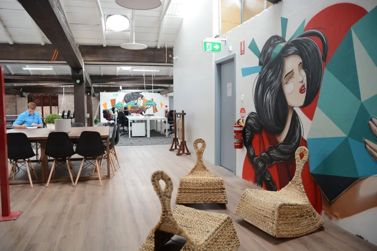 The HHQ coworking floor, with its big mural and exposed beams